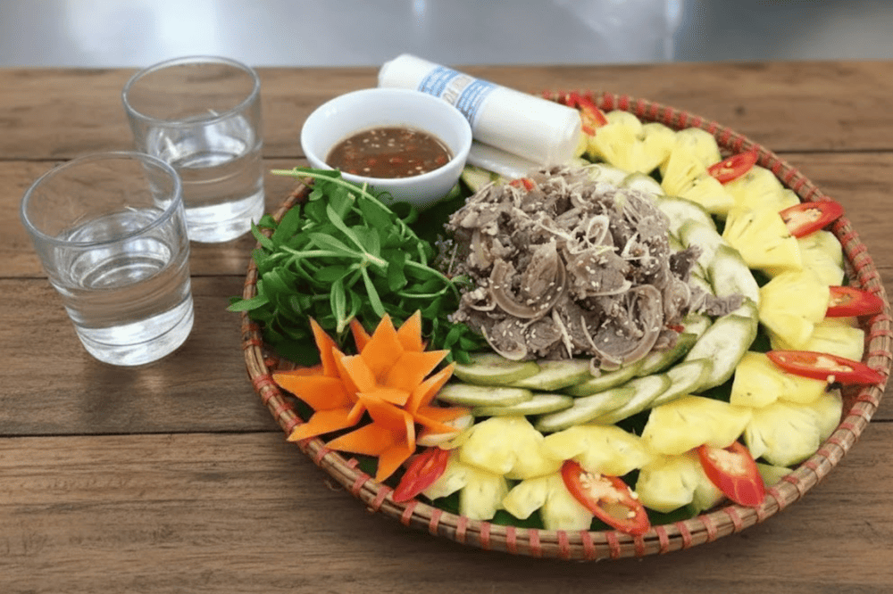 Món nem dê núi Ninh Bình tuyệt nhất khi ăn kèm với lá sung, lá ổi, khế, lá mơ, chuối xanh, rau thơm và chấm kèm tương gừng